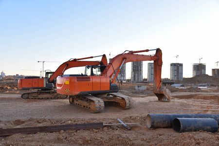Excavators working at construction site. Backhoe digs ground for the foundation and for paving out...