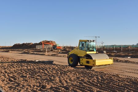 Soil Compactor the leveling soil at construction site. Excavator and vibration single-cylinder road...