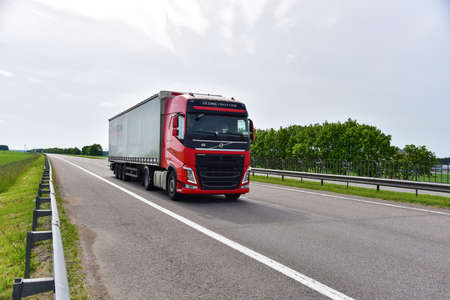 BELARUS - JUN 07, 2020: Truck VOLVO FH by Â«TRANSCOMÂ» with Semi-trailer driving along highway....