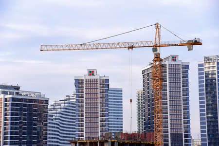 BELARUS, MINSK - MARCH 03, 2020: LIEBHERR tower crane constructing a new residential building at a construction site against blue sky.のeditorial素材