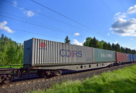 BELARUS, MARCH 24, 2020: Cargo containers by the Chinese rail operator CDiRS and CNINA SHIPPING transportation on freight train by railway. Intermodal Container On Train Car. Rail Freight Logisticsのeditorial素材