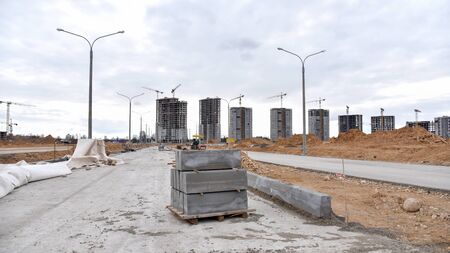 Screeding sand for installing borders, curbs and concrete blocks on the road. Laying paving slabs and bricks in the pedestrian zone. Road works, pavement renovation, asphalting at construction siteの写真素材