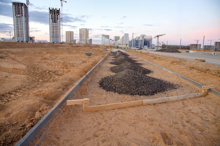 Laying paving slabs and borders at construction site. Process of installing paving bricks in the...