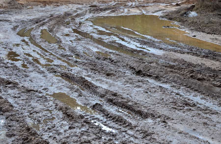 Broken dirt road after heavy rain. Swampy lagoon of a road demonstrates the most common problem in...