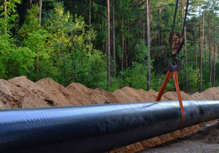 Natural gas pipeline construction work. A dug trench in the ground for the installation and installation of industrial gas and oil pipes. Crawler crane bulldozer with side boom or pipelayerの写真素材