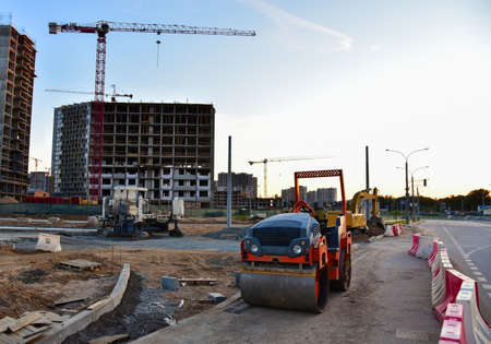Paving roller machine during road work. Road roller at construction site for paving works. Screeding...