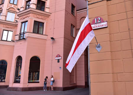 White-red-white flag hangs on a building. Protest rally at Independence Square against election result and police violence. MINSK, BELARUS - AUGUST 27, 2020のeditorial素材