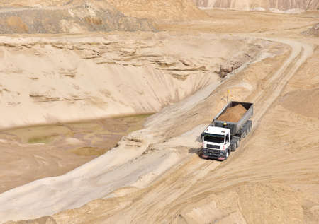 Truck with tipper semi trailer transported sand from the quarry. Dump truck working in open pit...