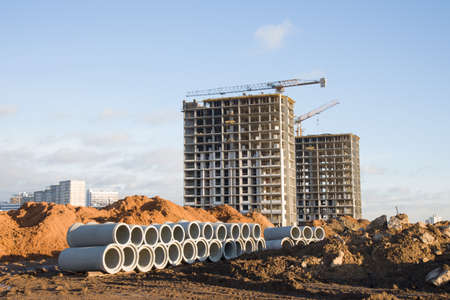 Tower cranes constructing a new residential build. Pouring concrete into formwork of building at...