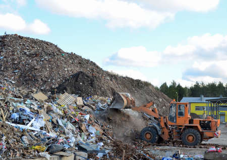 Front-end loader works in a landfill for the disposal of construction waste and other debris....