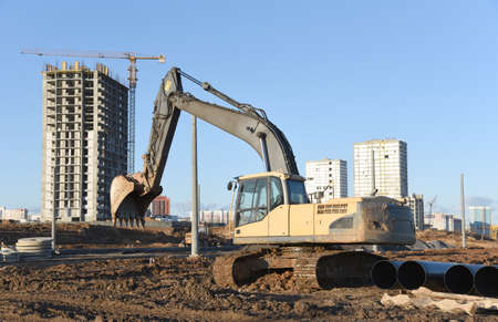 Excavator working at construction site. Backhoe digs ground for the foundation and for paving out...