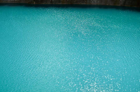 Turquoise clear ocean water background in summer tropical season. Transparent sea water texture with sunny reflections. Travel in paradiseの写真素材