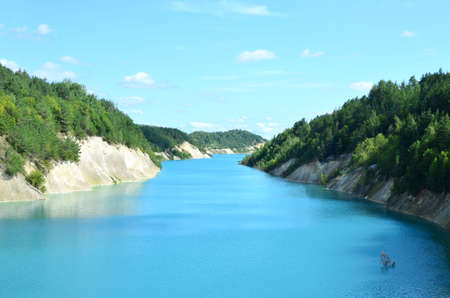 Artificial lake was formed after the extraction of chalk in an industrial quarry at Krasnoselsky village in the Belarus. Turquoise background of the clear ocean water in summer tropical season.の写真素材