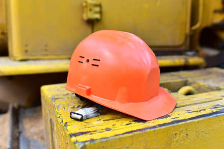 Red construction helmet. Headwear to protect the head of the worker when performing hazardous building work. Safety concept at the construction site. Working tools of the buildersの写真素材