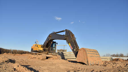 Excavator on earthworks at construction site. Backhoe on foundation work and road construction....