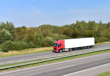 Truck with semi-trailer driving along highway. Goods delivery by roads. Services and Transport...
