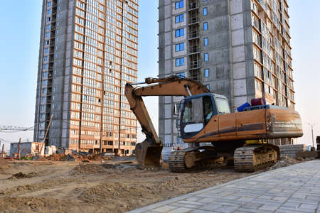 Excavator working at construction site. Backhoe on road work and earthworks. Earth-Moving Heavy...