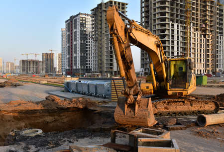 Excavator dig the trenches at a construction site. Trench for laying external sewer pipes. Sewage...
