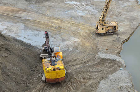 Excavator with electric shovel loading the rocks in mining truck at open pit mine. Rotary drilling...