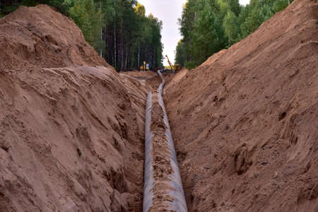 Natural gas pipeline construction work in forest area. Installation of gas and crude oil pipes.の写真素材