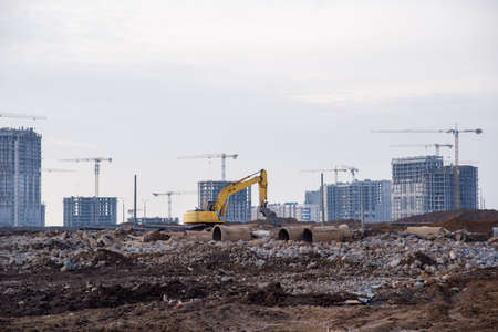 Excavator with hydraulic shears breaks asphalt and old concrete on construction site. Hydraulic shear crusher pulverizer for excavator. Heavy-duty mechanical concrete crusher. Attachments Equipmentの写真素材