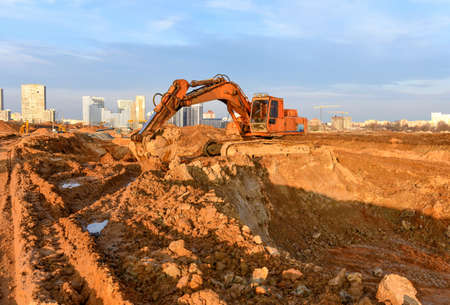 Excavator during excavation at construction site. Backhoe on Earthworks. Heavy Construction...