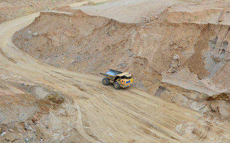 Mining truck transports sand in an open pit. View of the quarry where sand is mined. Mining industry concept. Out of focus, possible granularity, motion blurの写真素材