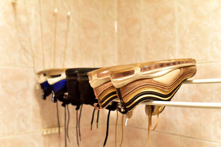 Sneakers to dry in the bathroom after washing. Three pairs shoes dry after wash. Footwear on heated towel rail to dry.の写真素材