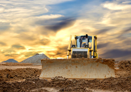 Dozer on earthmoving at construction site on awesome sunset background. Construction machinery and...