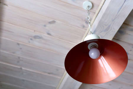 Lamp on the background of a wooden ceiling in a houseの写真素材