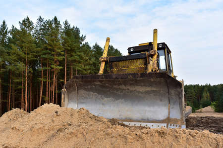Dozer during clearing forest for construction new road. Yellow Bulldozer at forestry work...