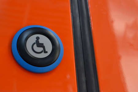 Button with sign wheelchair. Train door push button press to open sliding mechanical door at a train station platform. Special express train for disabled people.の写真素材