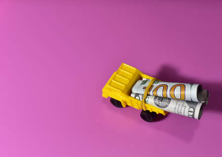 One hundred dollar bills in the back of a toy dump truck. Financial concept, business and money. Saving Money. Investmentsの写真素材