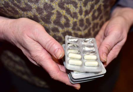 Pills and capsules in female hands. Medicine grade pharmaceutical tablets in packpage. Medical pill for maintaining and improving health. Antidepressant addiction concept. Depressionの写真素材