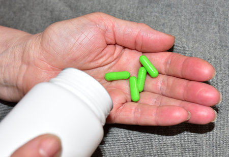 Pills in capsules in woomen hand. Medicine grade pharmaceutical tablets. Medical pill for maintaining and improving health. Grandma takes pills. Antidepressant addiction and depression concept.の写真素材