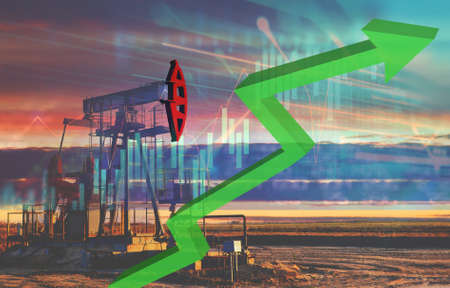 Crude mining concept and graph of falling oil prices on the trading exchange. Crude oil pump jack at oilfield on sunset backround. Fossil crude output and fuels oil production. Oil drill rigの写真素材