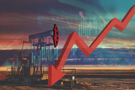 Crude mining concept and graph of falling oil prices on the trading exchange. Crude oil pump jack at oilfield. Oil drill rig and drilling derrick. Global crude oil Prices, energy, petroleum demandの写真素材