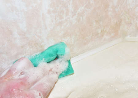 Sponge with detergent and foam while cleaning bathroom or toilet. Wash dishes and plumbing. Abrasive sponges for wash of dirty on ceramic. Detergents and anti-bacterial liquidsの写真素材