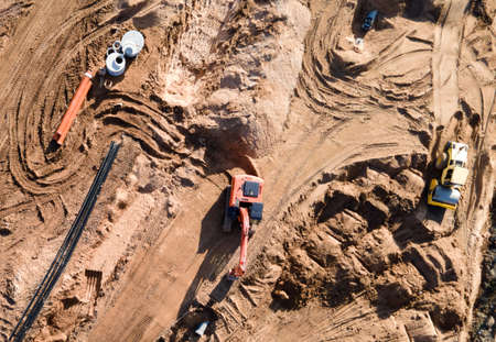 Installation of storm sewers and construction of a road in a new residential area. Excavator on...