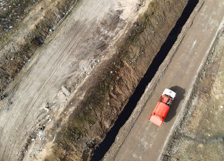 View from a drone to a garbage truck on a landfill with wasteの写真素材