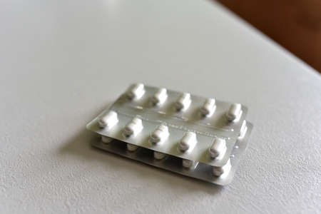 Pills in packpage on table. Medicine grade pharmaceutical tablets. Medical pill for maintaining and...