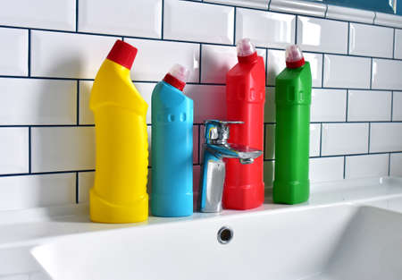 Detergent bottles and detergent spray cleaner in the bathroom on washbasin. Household for cleaning...