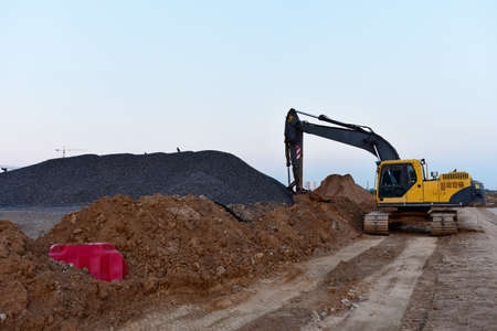 Excavator on earthworks at construction site. Backhoe on earthmoving and foundation work. Heavy...