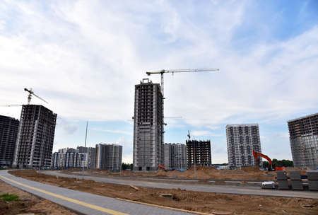 Tower cranes in action at construction site. Construction process of the new modern residential...