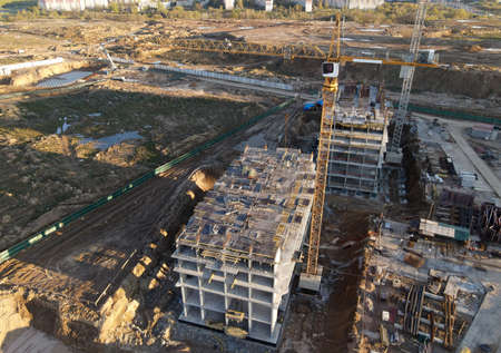 Tower cranes in action at construction site. Crane during formworks. Soil Compactor leveling ground...