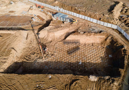 First floor slab rebar installation. Pile driver at construction site. Pile driven into ground by...