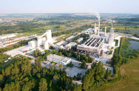 View of the cement plant with pipes. Industrial factory with smoke frow pipe. Chimney smokestack...