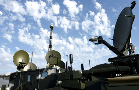 Radar for warning of the appearance of a target and the detection and location of objects. Military locator and antenna equipment vehicle. War or military concept on sunset background. Army exercisesの写真素材