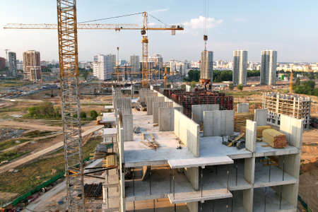 Crane during formworks on construction site. Pouring concrete into formwork. Construction the buildings and multi-storey residential homes. Tower cranes at construction and the built environment.の写真素材