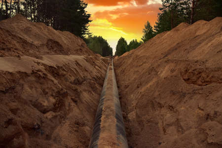 Natural Gas Pipeline Construction. Laying oil pipe in a trench in the ground. Petrochemical industry...